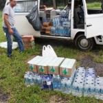 Alimentos não perecíveis, leite e água doados pelo Move Rio são levados para o ginásio de São José para serem escoados